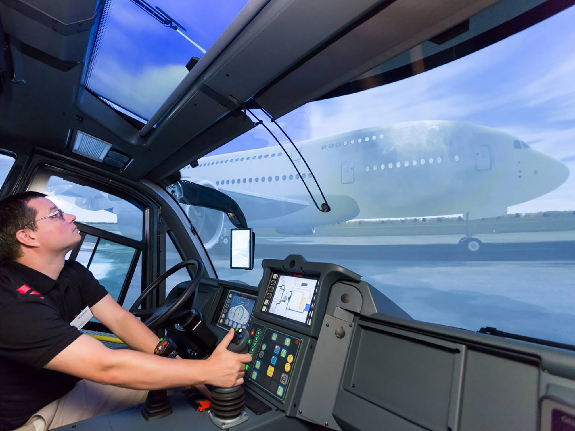 A trainee is operating the HRET to extinguish an A-380 interior fire from inside a full cabin ARFF simulator.