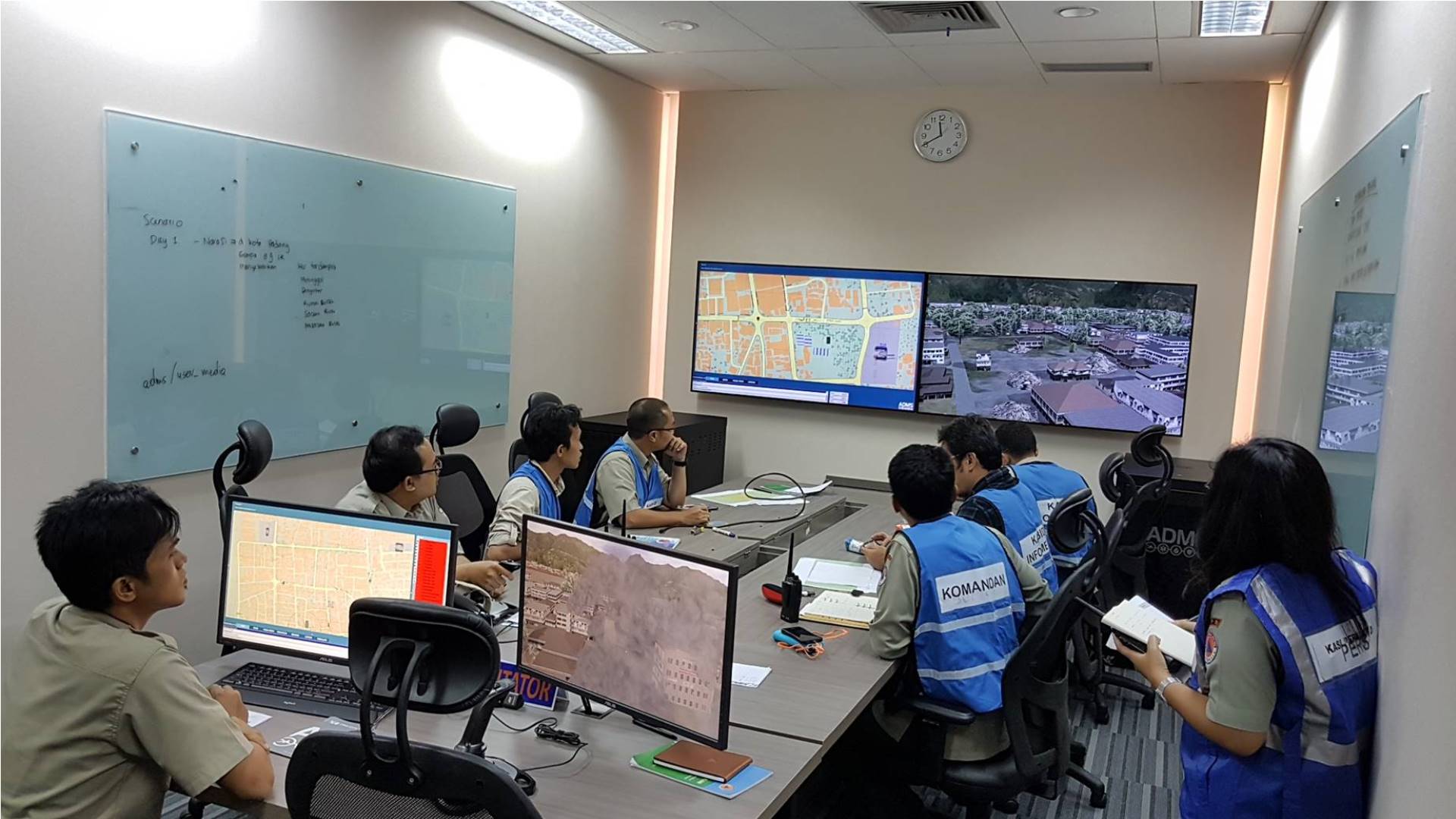 Emergency Operation Center Trainees responding to an Earthquake scenario with a map and live feeds of the area. 